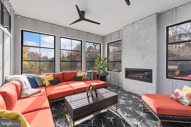 living area with a fireplace and ceiling fan