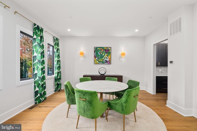 dining room featuring light wood-type flooring, baseboards, visible vents, and recessed lighting