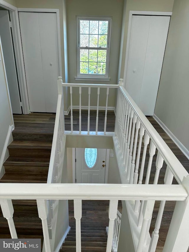 stairs featuring wood finished floors and baseboards