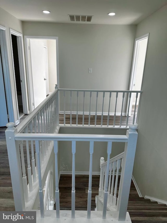 stairs with baseboards, wood finished floors, visible vents, and recessed lighting