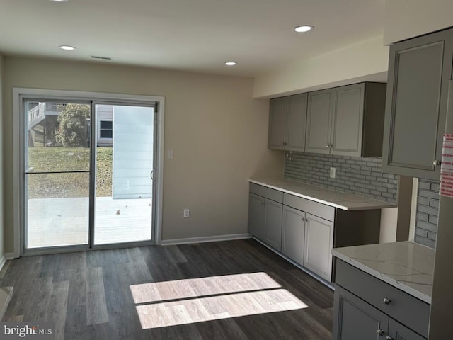 kitchen with dark wood-style floors, backsplash, and gray cabinetry