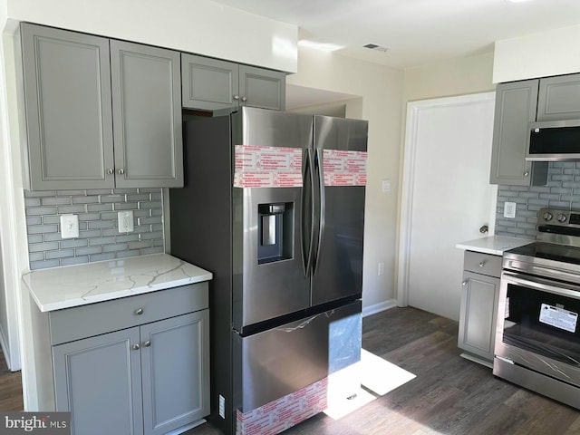 kitchen with stainless steel appliances, dark wood-type flooring, and gray cabinetry