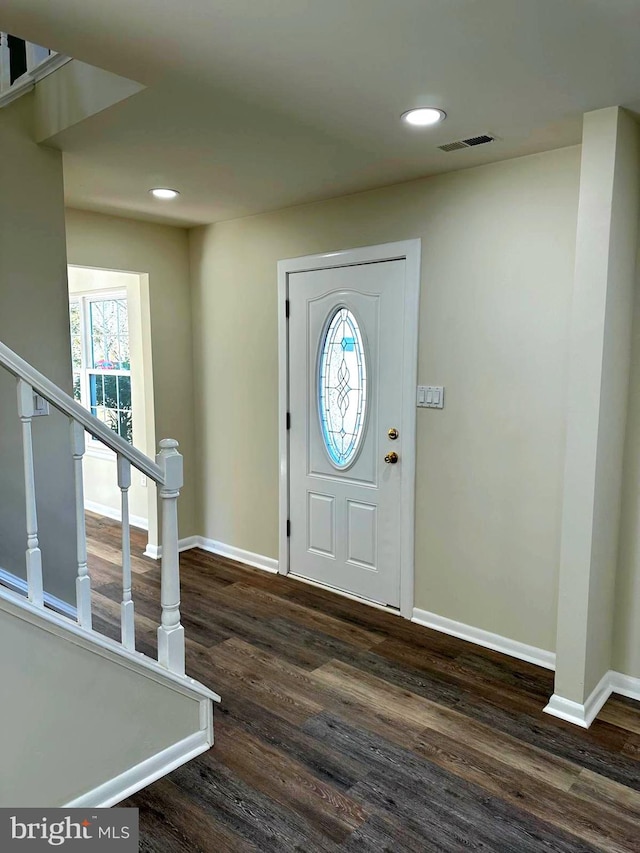 entrance foyer featuring dark wood-style flooring, visible vents, and baseboards