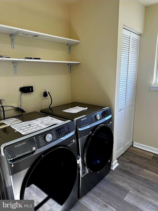 laundry area featuring laundry area, wood finished floors, washing machine and dryer, and baseboards