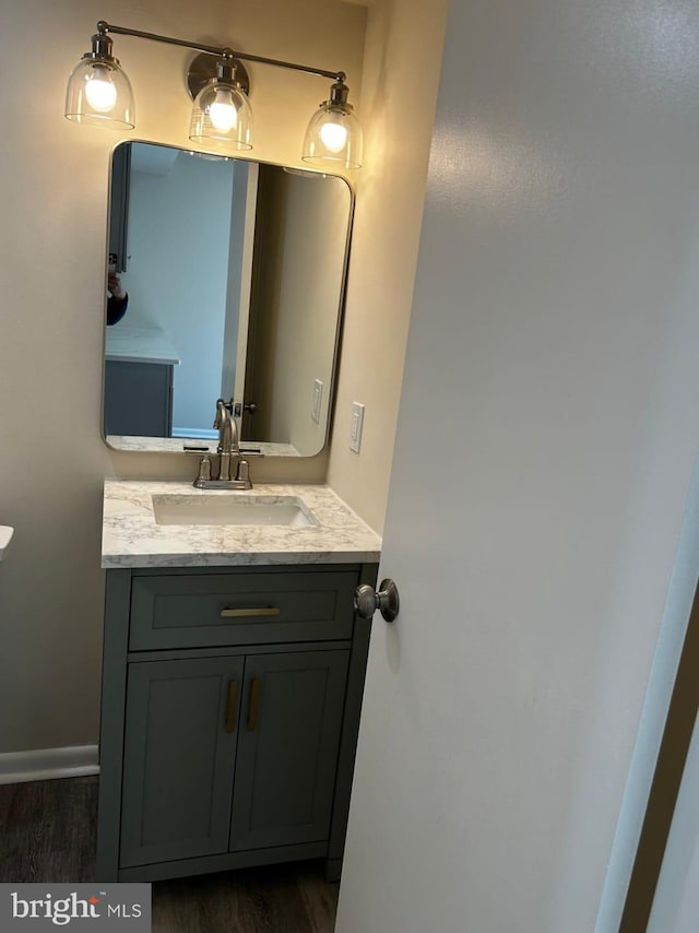 bathroom featuring wood finished floors, vanity, and baseboards