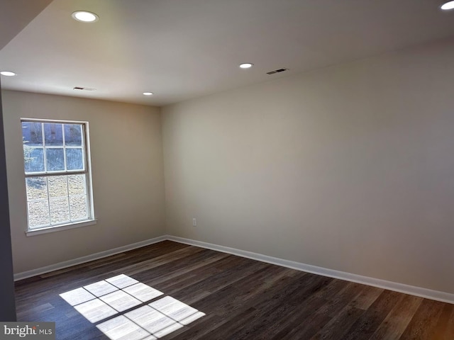 empty room featuring dark wood-style floors and baseboards