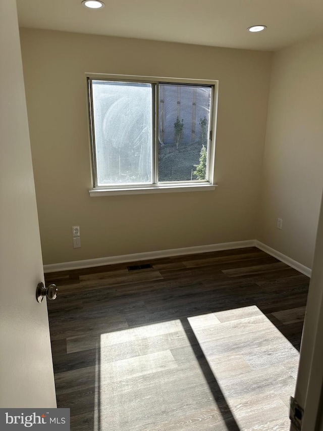 empty room with recessed lighting, visible vents, baseboards, and wood finished floors