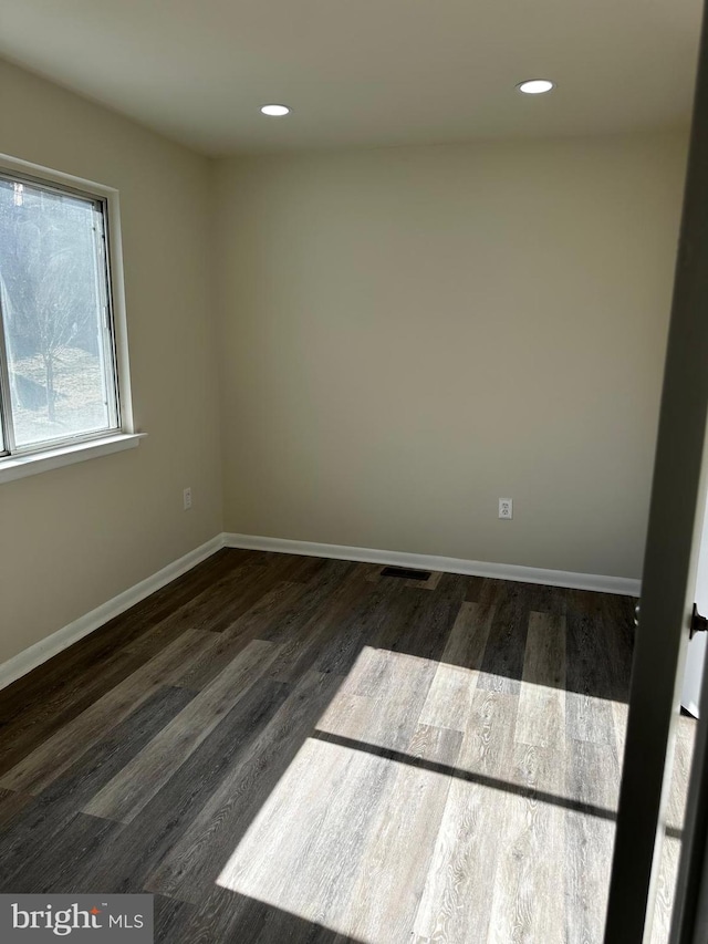 unfurnished room featuring baseboards, wood finished floors, and recessed lighting