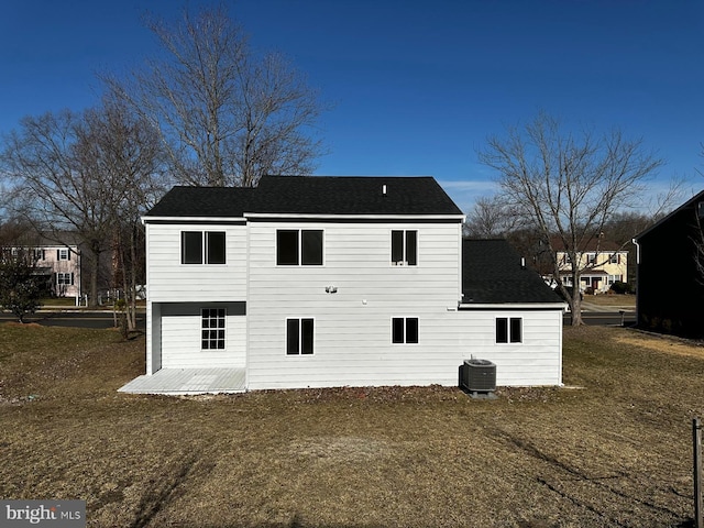 back of property featuring central AC and a yard