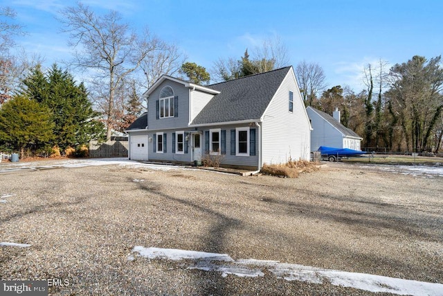 view of front of home with a garage, driveway, roof with shingles, and fence