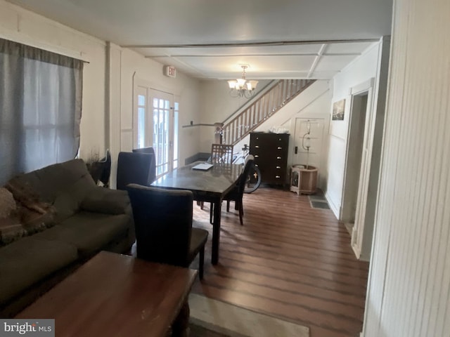 dining space with a notable chandelier, stairway, and wood finished floors