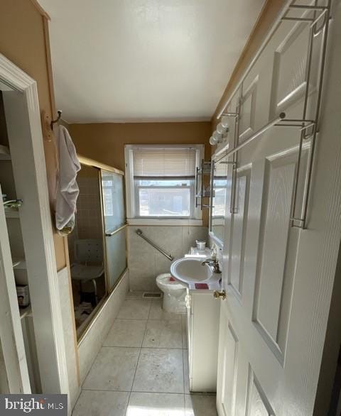 bathroom featuring toilet, a stall shower, tile patterned flooring, and vanity