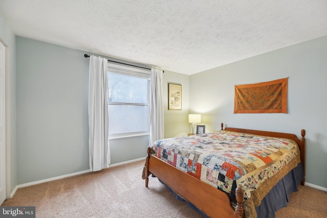 carpeted bedroom featuring a textured ceiling and baseboards