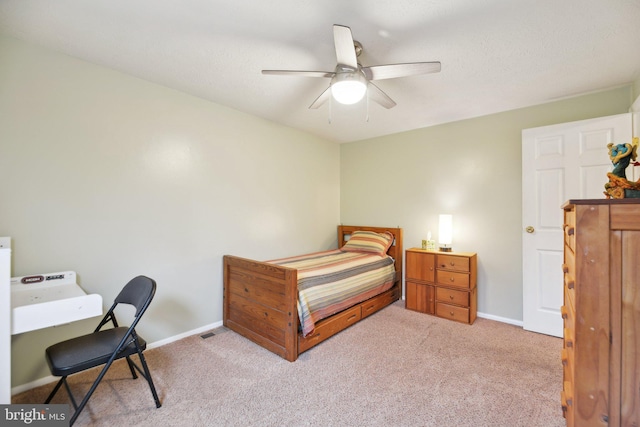 bedroom featuring light carpet, ceiling fan, visible vents, and baseboards