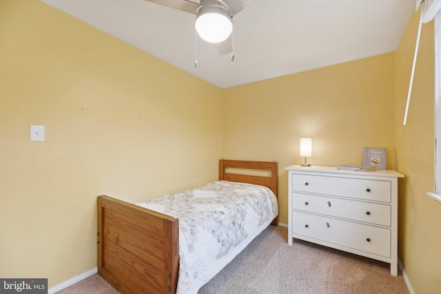 carpeted bedroom with ceiling fan and baseboards