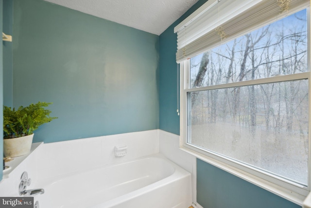 bathroom featuring a textured ceiling and a bath