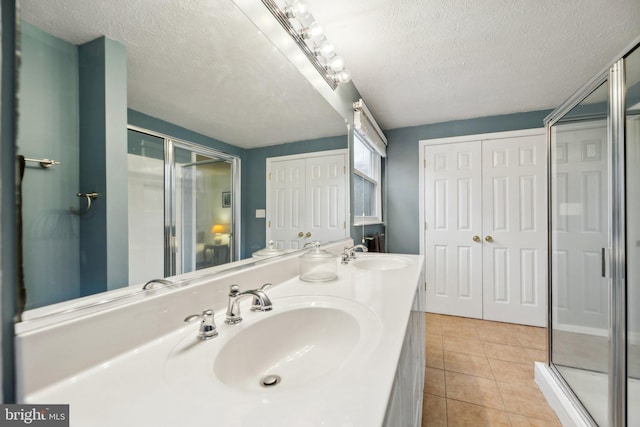 full bathroom with tile patterned flooring, a sink, and a shower stall