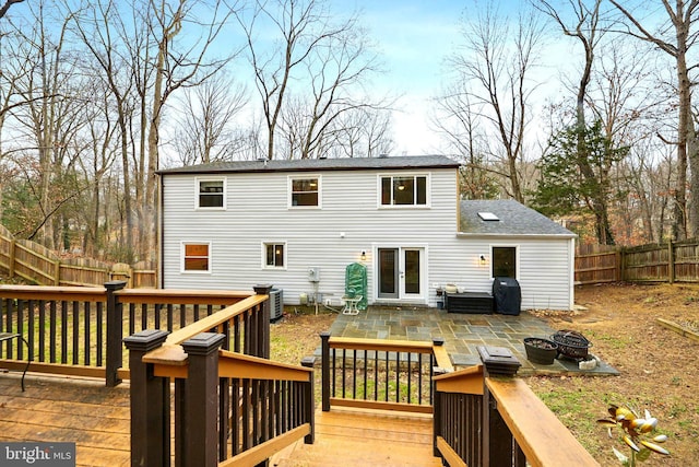 deck with an outdoor fire pit, area for grilling, a fenced backyard, french doors, and central AC