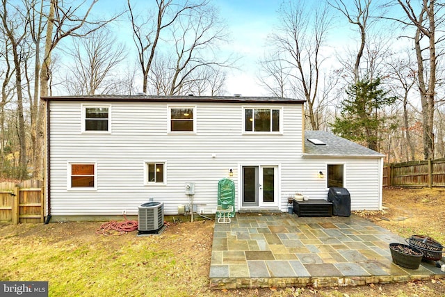 back of house featuring an outdoor fire pit, a shingled roof, fence, a patio area, and central AC