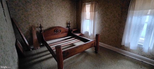 bedroom featuring baseboards and wallpapered walls