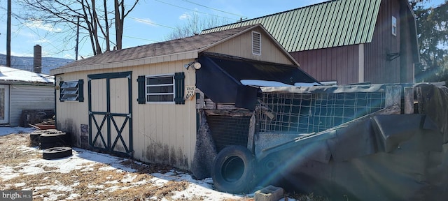 view of snowy exterior featuring an outbuilding