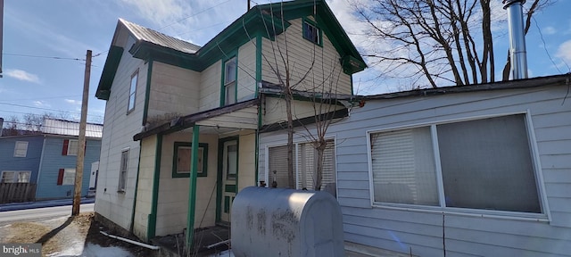 view of side of property with metal roof and heating fuel