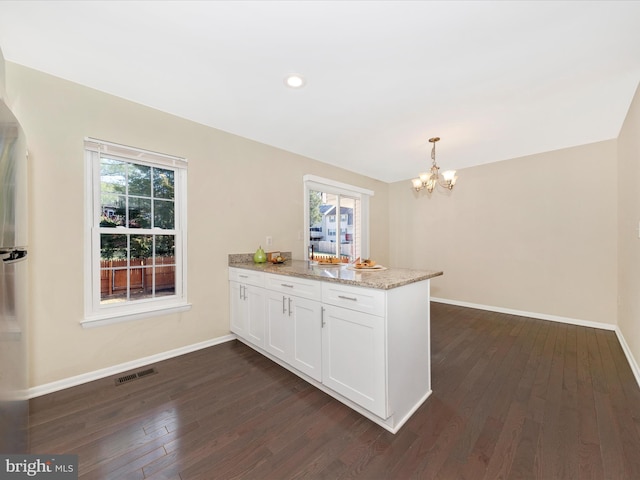 kitchen with baseboards, visible vents, white cabinets, dark wood-style flooring, and a peninsula