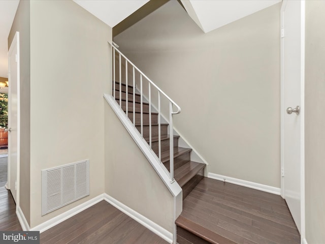 stairs featuring wood finished floors, visible vents, and baseboards