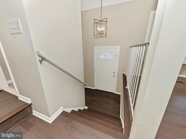 foyer entrance with stairs, baseboards, and wood finished floors