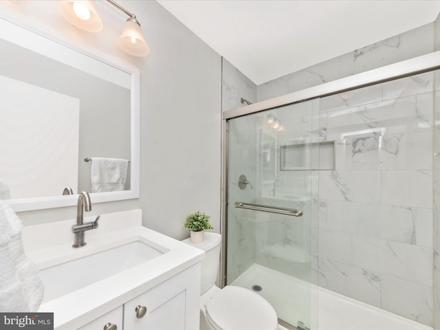 full bathroom featuring vanity, a marble finish shower, and toilet