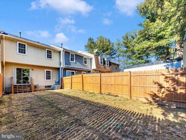 rear view of property with entry steps and fence