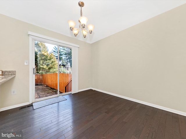 unfurnished dining area with baseboards, dark wood-style flooring, visible vents, and a notable chandelier