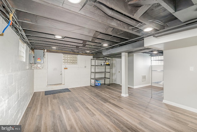 below grade area featuring visible vents, wood finished floors, electric panel, and baseboards