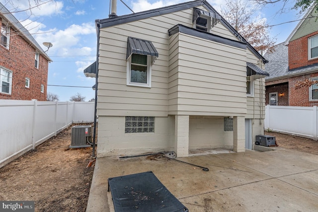 back of property featuring an attached garage, a patio area, a fenced backyard, and cooling unit