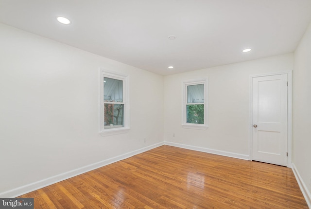 spare room featuring recessed lighting, wood finished floors, and baseboards