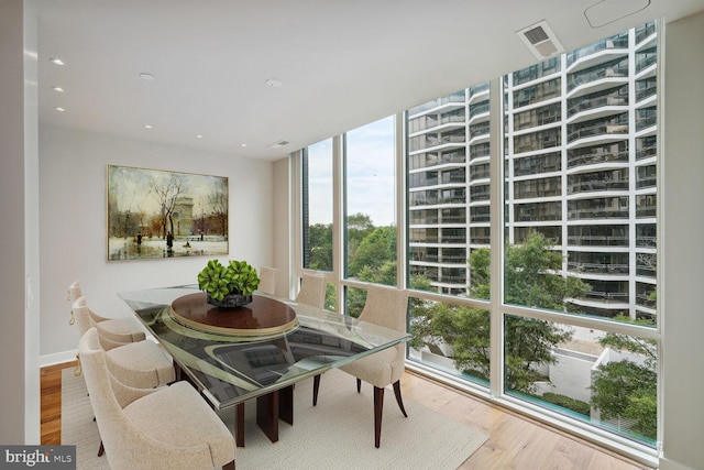 dining space featuring a wall of windows, wood finished floors, and recessed lighting