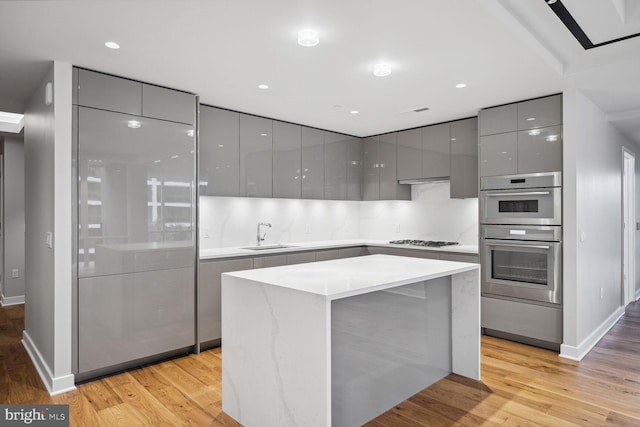 kitchen featuring light wood-type flooring, stainless steel appliances, modern cabinets, and gray cabinets