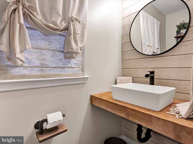 bathroom with a sink and wooden walls