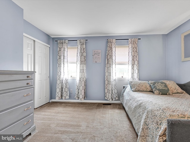 bedroom with visible vents, a closet, baseboards, and carpet flooring