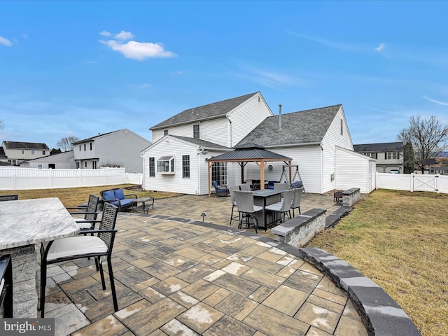 back of house featuring a patio, a fenced backyard, a gate, outdoor dining area, and a gazebo