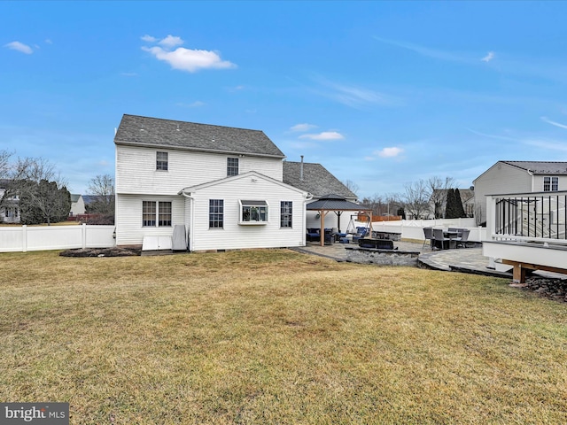 rear view of property featuring fence, a deck, a gazebo, and a lawn