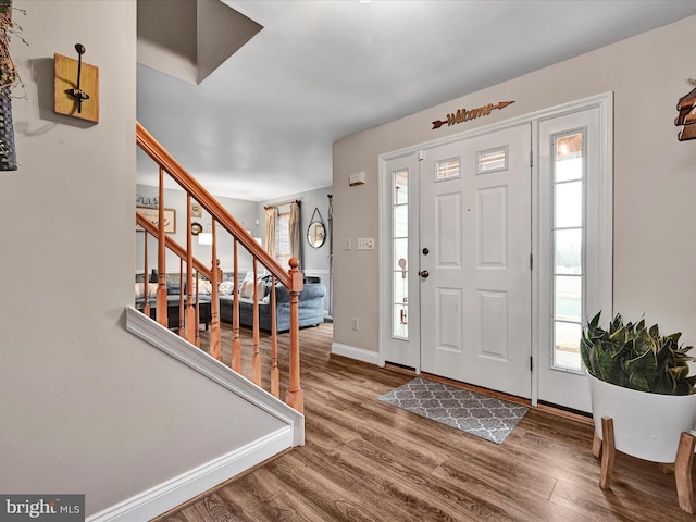 foyer featuring stairs, wood finished floors, and baseboards