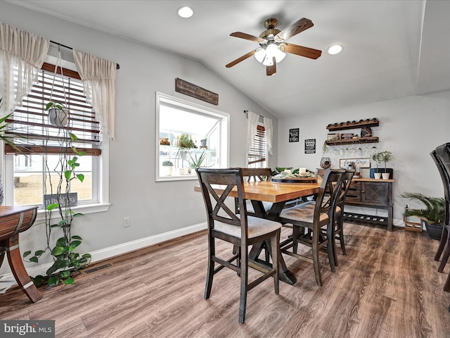 dining space featuring lofted ceiling, visible vents, baseboards, and wood finished floors