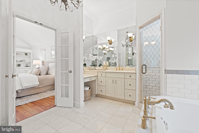 506 Ivy Cir, Alexandria, VA 22302 - ensuite bathroom featuring tile patterned flooring, a bath, a chandelier, and vanity