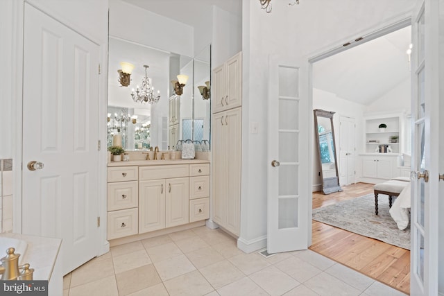 506 Ivy Cir, Alexandria, VA 22302 - bathroom featuring an inviting chandelier, vanity, lofted ceiling, tile patterned floors, and built in shelves