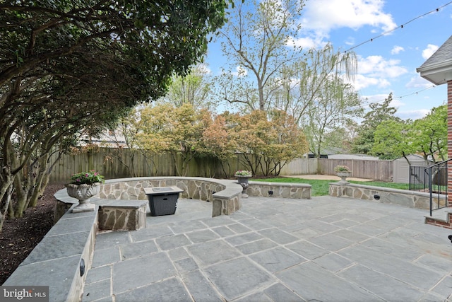 506 Ivy Cir, Alexandria, VA 22302 - view of patio featuring an outbuilding, a fenced backyard, an outdoor fire pit, and a storage shed