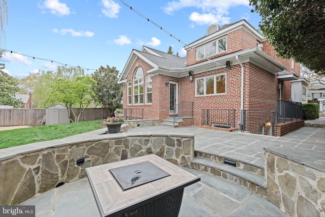 506 Ivy Cir, Alexandria, VA 22302 - back of house with a shed, an outdoor fire pit, a patio area, fence, and brick siding