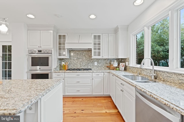 506 Ivy Cir, Alexandria, VA 22302 - kitchen featuring white cabinets, appliances with stainless steel finishes, a sink, premium range hood, and light wood finished floors