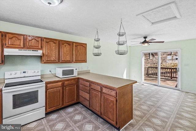 kitchen with under cabinet range hood, a peninsula, white appliances, brown cabinets, and light floors