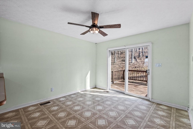 spare room with visible vents, a ceiling fan, a textured ceiling, baseboards, and tile patterned floors